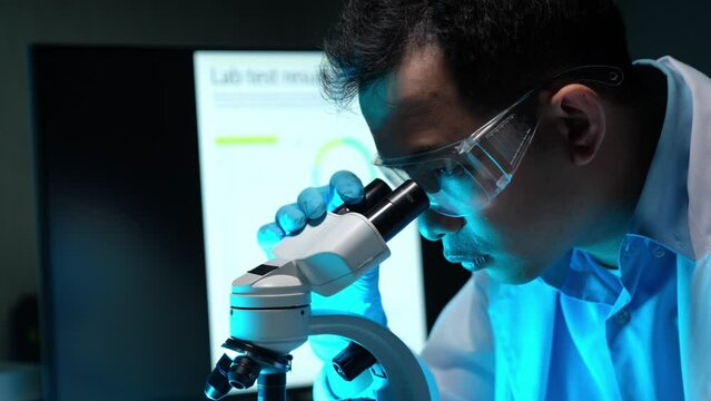 Medical science laboratory Portrait of scientist looking under microscope analyzing test sample. Biotechnology experts work with advanced equipment.