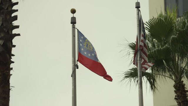 Georgia (state) and United States flag flapping in wind with palm trees and building