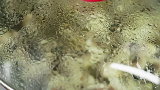 glass lid of skillet with condensed water drops, slow motion closeup.