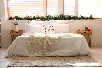 Stylish interior of light bedroom decorated for Christmas
