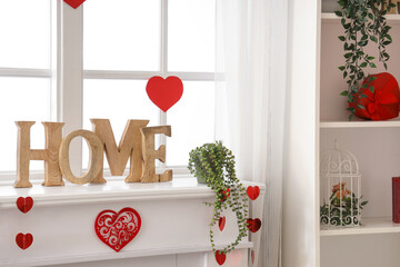 Mantelpiece with decorative word HOME and hearts for Valentine's Day celebration near window - obrazy, fototapety, plakaty