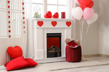 Interior of festive living room with fireplace, pouf and decorations for Valentine's Day celebration