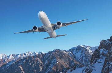 Fototapeta na wymiar Front view of the passenger airplane flies climb taking off over the pass background of high picturesque mountains