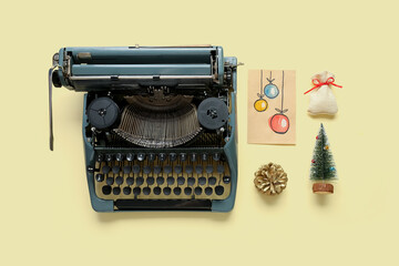 Vintage typewriter with Christmas decor on yellow background