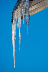 Icicles on the eaves of the roof on a winter day