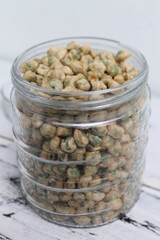 Indonesian snack called flour fried peas (kacang polong) in a jar on the table
