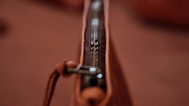Close up of a zipper on a hand made caramel leather bag