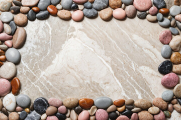 Fototapeta na wymiar background frame of colorful pebbles on white marble