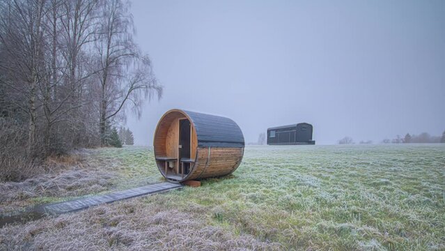 Timelapse of a sauna and a cabin, weather and seasons changing on the countryside