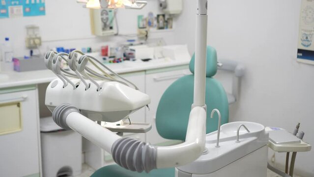 Side view of a modest dental clinic without people showing the dentist's equipment necessary to treat oral ailments. Dentist's profession concept