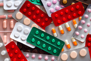 Many different medical tablets in blisters. Texture of multi-colored pills.
