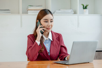 An entrepreneur is talking on the phone with a company customer, Beautiful woman in the office, happy, businesswoman uses internet phone close up, businesswoman checks email on smartphone,