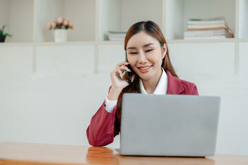 An entrepreneur is talking on the phone with a company customer, Beautiful woman in the office, happy, businesswoman uses internet phone close up, businesswoman checks email on smartphone,