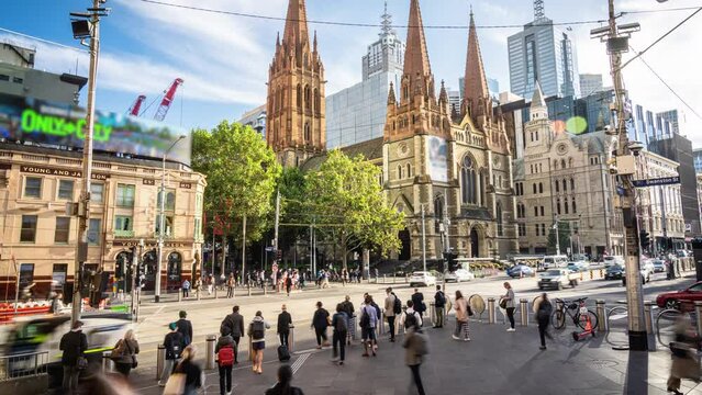 Time Lapse of Crowded Commuter and Tourist walking and crossing road at Flinders Street Railway Station with St Paul's Cathedral in Melbourne City, Victoria, Australia