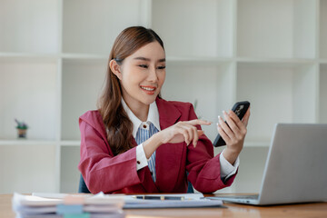 An entrepreneur is talking on the phone with a company customer, Beautiful woman in the office, happy, businesswoman uses internet phone close up, businesswoman checks email on smartphone,