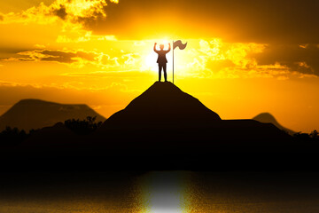 Silhouette of person with flag on mountain top over sky and sunlight background at sunset with copy space