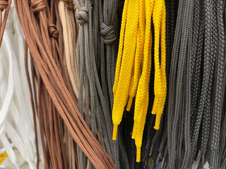 Shoe laces of different colors in a store, close-up.