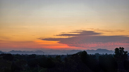 Evening light. Sunset casting red and orange light. Sunset over countryside.