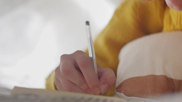 Woman writing journaling in diary 