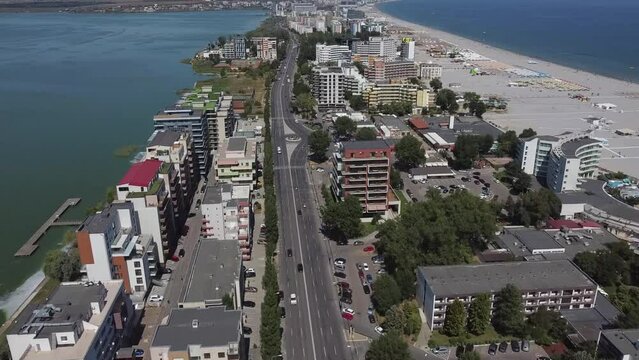 Approaching drone shot of a strip of land where hotels, condominiums, restaurants, and other entertainment establishments are located, at the beachfront of Mamaia resort, in Constanta, Romania.