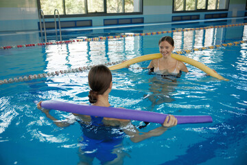 Female fitness class of aqua aerobics at indoors swimming pool