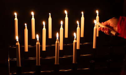 fire up a candle with a hand, cluster of candles