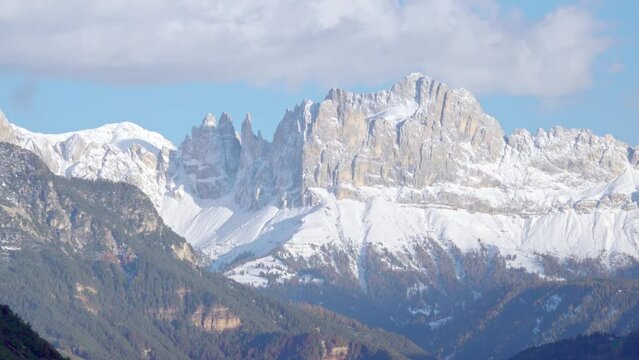 Zooming out on Latemar and Rosengarten Massif with Mount Tschafon, South Tyrol, Italy, on a sunny day in late autumn.