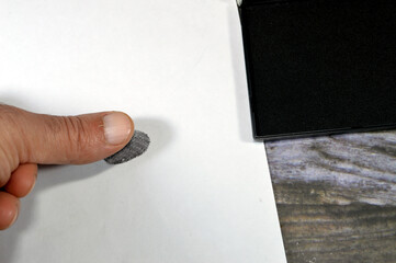 A fingerprint  and a black color stamp ink pad, finger print is an impression left by the friction...