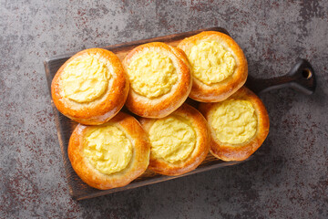 Shanga pies, a dish of Russian, Mari, Udmurt and Komi cuisine, filled with mashed potatoes, close-up on a wooden board on the table. Horizontal top view from above