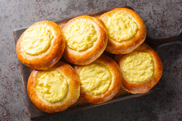 Shangi baked pies with potatoes Russian pastry closeup on the wooden board on the table. Horizontal top view from above
