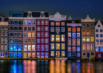 Amsterdam at night with dancing colorful houses at the Amsterdam canals in the Netherlands....