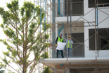 Engineer and architect working on the construction site, double-checking plans and process.