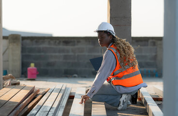 Young female architect working on a construction site with a laptop in her hands
