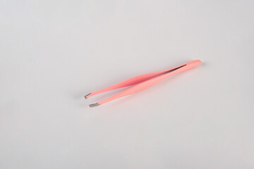 Pink hair tweezers isolated on white background