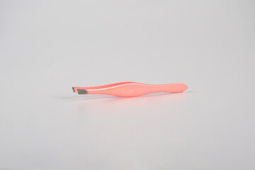 Pink hair tweezers isolated on white background