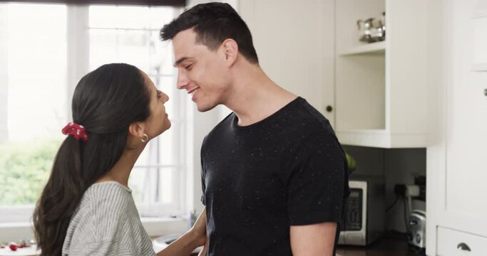 Conversation, love and couple kiss in kitchen, care and bonding together in home. Happy man, woman and touch lips, romantic connection and healthy relationship, talking and smile on valentines day