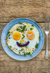 sunny side up fried egg with smiling face shape on plate