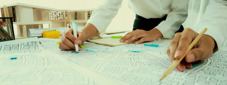 Worker, architect and engineer work on real estate construction project oratory planning with cartography and cadastral map of urban town area to guide to construction developer business plan of city