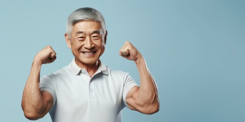 An older man showcasing his strength by flexing his muscles on a vibrant blue background. Perfect for fitness and health-related concepts - obrazy, fototapety, plakaty