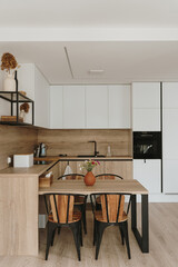 Modern Nordic Scandinavian home interior design. Bright open space living room with dinner table, kitchen furniture, chairs, decorations. Elegant apartment for rent concept