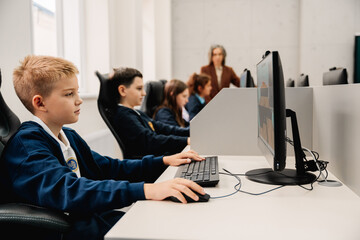 Group of children using personal computers during computer science class at school