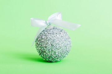 Christmas ball on colored background. decoration bauble with ribbon bow with copy space