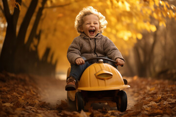 Laughing boy riding a pedal car in autumn - obrazy, fototapety, plakaty