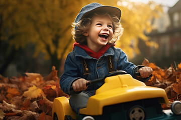 laughing boy in toy car in autumn