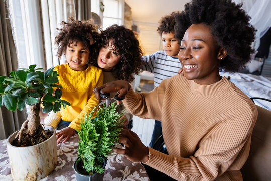Happy lesbian, homosexual women couple gardening with children and learning botany.