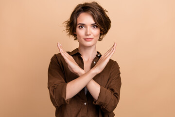 Photo of pretty confident lady wear brown shirt arms crossed showing no gesture isolated beige...