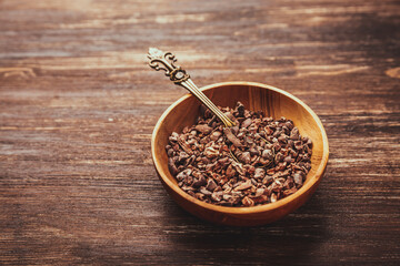 Cocoa bean nibs  in small bowl - baking ingredients