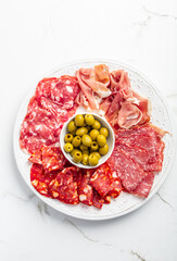 Assortment of Italian and Spanish sliced meat appetizer, prosciutto, salami and ham, with olives