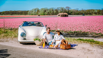 Lisse Netherlands a couple doing a road trip with an old vintage car in the Dutch flower bulb...