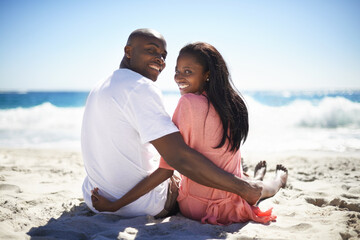 Fototapeta premium Rear, portrait and smile with a black couple on the beach for travel, romance or adventure together. Summer, love or dating with a happy young man and woman sitting on the sand by the ocean or sea